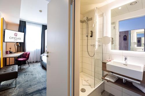 a bathroom with a sink and a shower at CityClass Hotel am Dom in Cologne