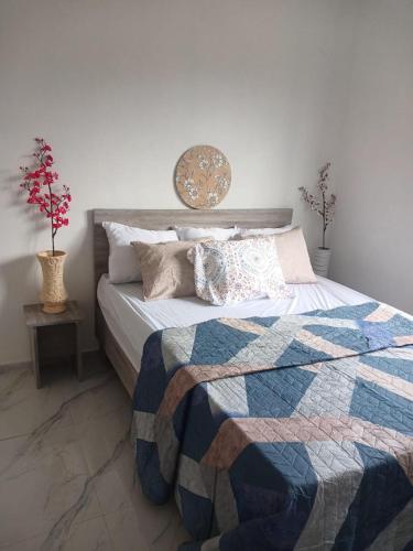 a bedroom with a bed with a quilt on it at Sunrise Bay Villa in Mahébourg