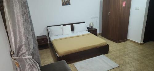 a bedroom with a bed with white pillows at NHYIRA Hotel in Sekondi-Takoradi