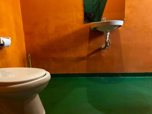 a bathroom with a toilet and a sink at East Homestay in Boma la Ngombe