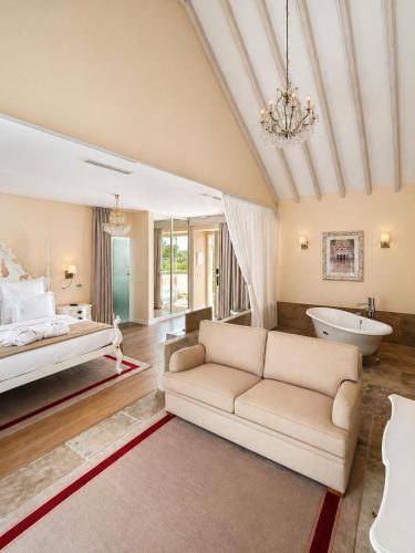 a living room with a couch and a bed and a tub at Quinta da Maquia Hotel in Sintra