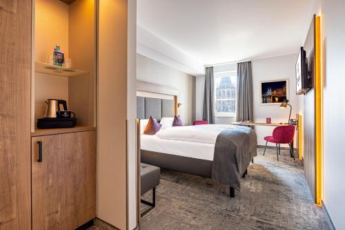 a hotel room with a bed and a desk at CityClass Hotel am Dom in Cologne
