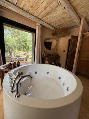 a white tub in a bathroom with a window at LA PAUSE Chisà in Chisa