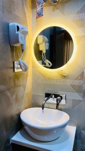 a bathroom with a white sink and a mirror at StayMooddy in Indore