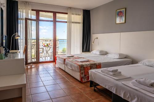 ein Hotelzimmer mit zwei Betten und Balkon in der Unterkunft Prestige Grand Hotel & Aquapark - All Inclusive in Goldstrand