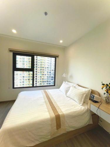 a bedroom with a large white bed with a window at Toà gh6 in Gò Công