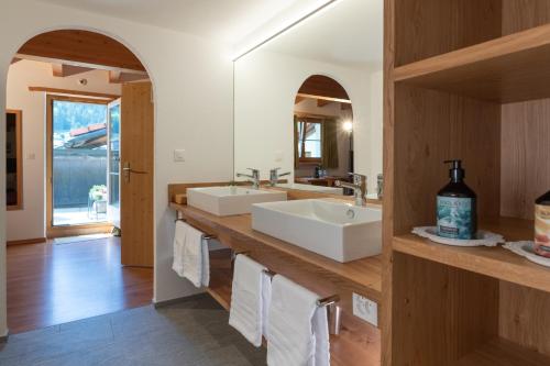 a bathroom with two sinks and a large mirror at Sport-Lodge Klosters in Klosters
