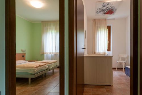 a bedroom with a bed and a room with a kitchen at Casa Lucia 1 in Crone