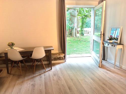 a dining room with a table and chairs and a door at Le havre du voyageur in Charly