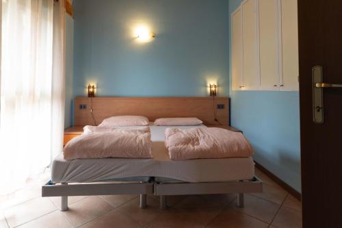 a bed in a bedroom with a blue wall at Casa Flora in Crone