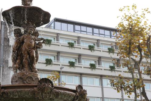 a statue of an angel standing in front of a building at Hotel Litteraire Alexandre Vialatte, BW Signature Collection in Clermont-Ferrand