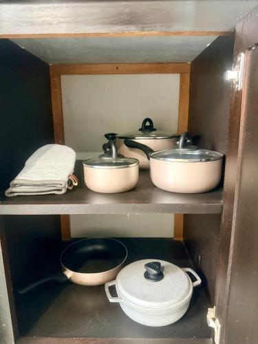a kitchen with pots and pans on a shelf at A Hidden Gem 2BR apartment in Couva