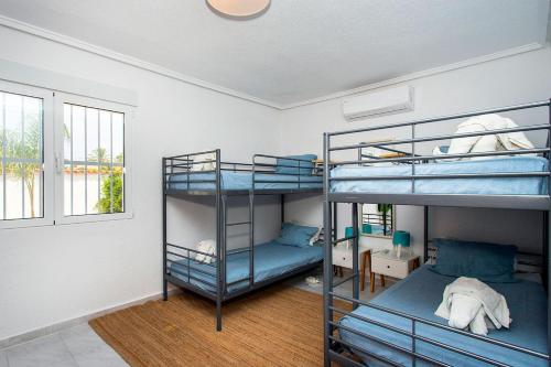 a room with three bunk beds and a window at CH Villa Mare Ciudad Quesada in Ciudad Quesada