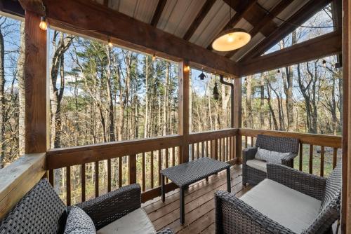 a screened in porch with chairs and a table at Fox Trail Cabin in Boone