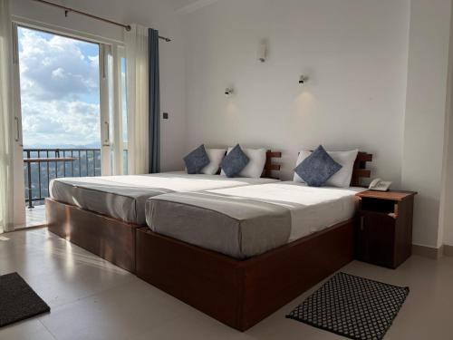 a bedroom with a large bed with a large window at Golden Sky Hotel & Wellness in Kandy