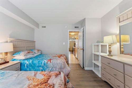 a bedroom with two beds and a dresser and a mirror at 3110 Atlantic Ave, Unit 304 in Wildwood