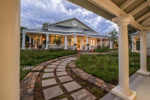 a home with a stone walkway in front of a house at The Royal Fischer Hotel in Bloemfontein