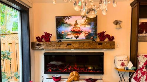 a living room with a television above a fireplace at Peterborough Zen Retreat in Peterborough