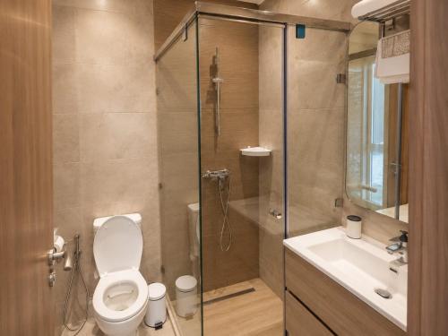 a bathroom with a shower and a toilet and a sink at Pool View Apartment Gated Residence in Sidi Rahal