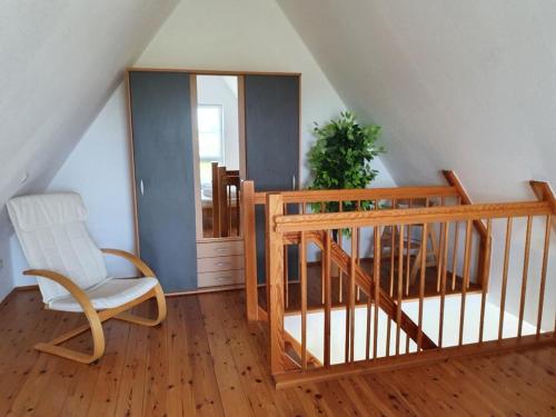 a room with a staircase with a chair and a mirror at Ruhige, moderne Maisonette Ferienwohnung Rügensonne mit großem Balkon - umgeben vom Wasser in Breege