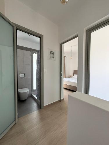 a room with a bathroom with a toilet and a bedroom at Almira Suites by the sea 3 in Áyios Dhimítrios