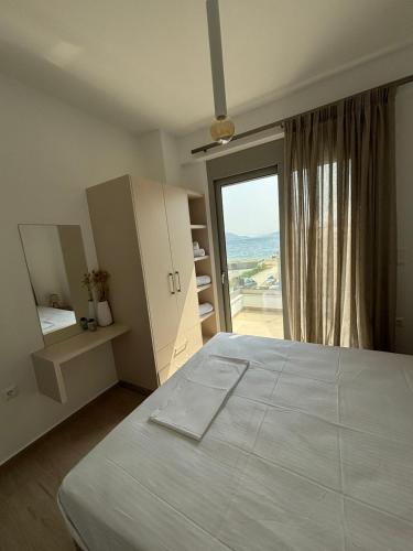 a bedroom with a large white bed and a window at Almira Suites by the sea 3 in Áyios Dhimítrios