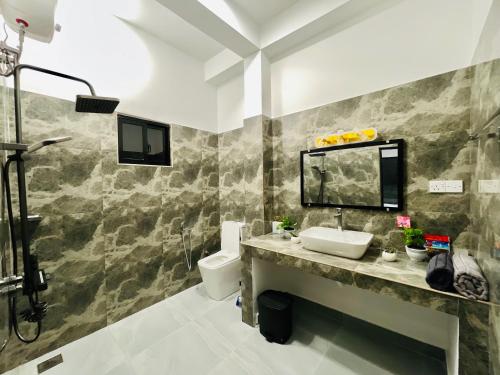 a bathroom with a sink and a toilet at The Ocean Deck Apartments in Moragalla