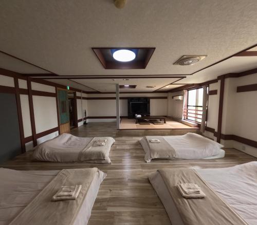 a room with three beds and a tv in it at Aizuwakamatsu Piacere in Aizuwakamatsu