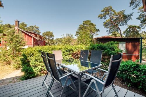 a glass table and four chairs on a deck at Ferienhaus am Strand 88 - Bade- & Saunawelt täglich inklusive in Baabe