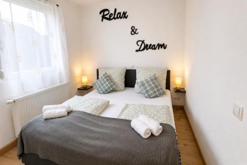 a bedroom with a bed and a sign that reads relax and dream at Comfortable new Apartment in #Koblenz# direkt am Rhein in Koblenz