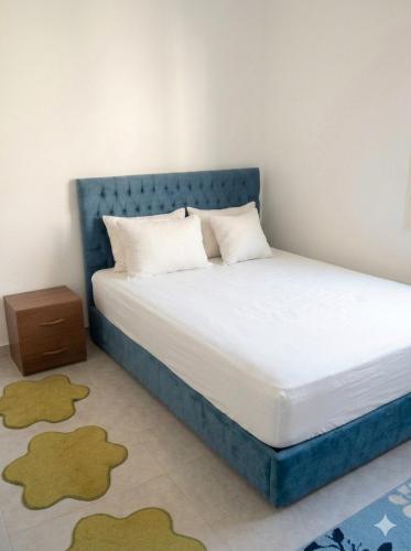 a bed with a blue headboard in a room at dalina resort in El Alamein