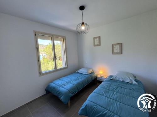 a bedroom with two beds and a window at Le canigou in Fuilla