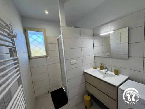a white bathroom with a sink and a mirror at Le canigou in Fuilla