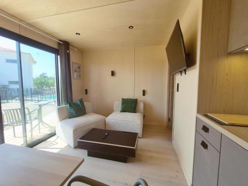 a small living room with a couch and a table at Filao - Clim Piscine in Auch