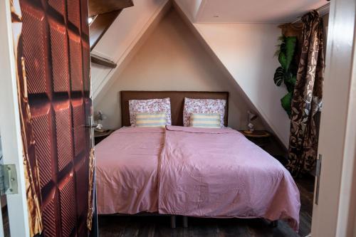 a bedroom with a bed with a purple bedspread at Slapen bij Ticho in Yerseke