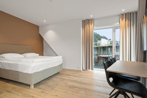 a bedroom with a bed and a table and chairs at Skudeløken Apartment Hotel in Førde