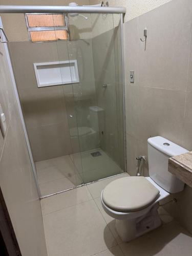 a bathroom with a toilet and a glass shower at Aconchego da serra no centro de Pacoti in Pacoti