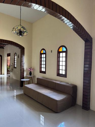 a large couch in a living room with windows at Aconchego da serra no centro de Pacoti in Pacoti