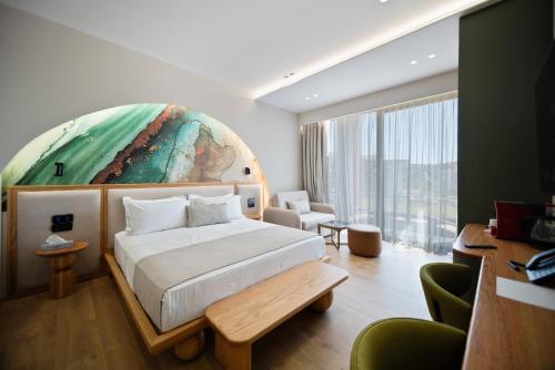 a bedroom with a bed and a large painting on the wall at Hotel Potami in Himare