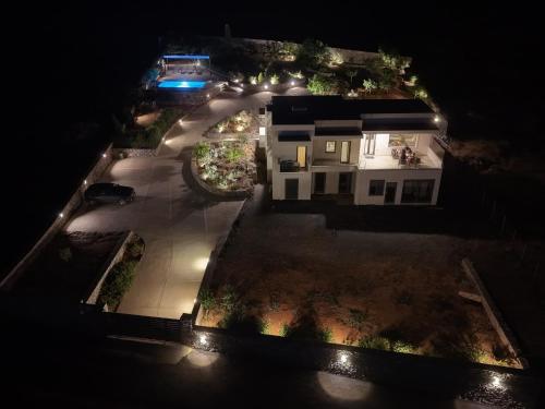an aerial view of a house at night with lights at Terra Della Salvia Villa with heated pool in Gouves