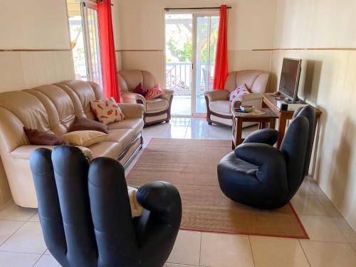 a living room with leather chairs and a couch at Maison de charme avec vue sur mer à Bas Vent - Confort optimal in Bas Vent