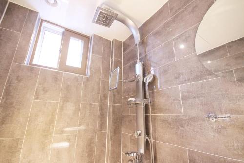 a bathroom with a shower with a mirror at 벨린 호텔 in Kŏje
