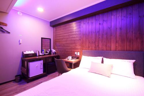 a bedroom with a bed and a desk with a television at 벨린 호텔 in Kŏje
