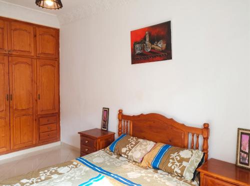 a bedroom with a bed with a wooden head board at Modern apartment near Oujda - 80 m² - 8 guests in Oujda
