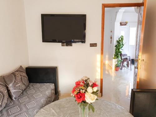 a living room with a couch and a vase of flowers on a table at Modern apartment near Oujda - 80 m² - 8 guests in Oujda