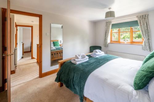 a bedroom with a bed and a mirror at Acorn House in Briston