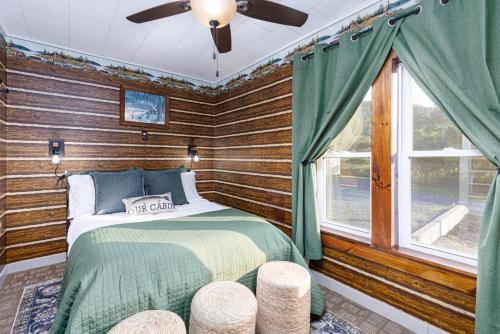 a bedroom with a bed in a room with wooden walls at The Old Homestead in Roulette