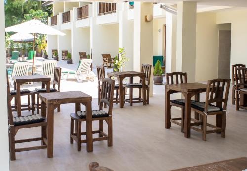a group of wooden tables and chairs in a room at Cozy apartment in Ko Samui 64 m² with shared pool in Thong Son Beach