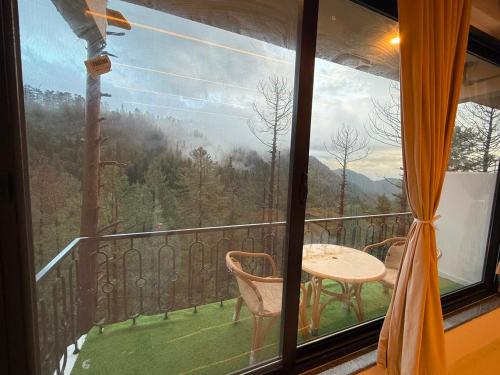 a view of a balcony with a table and chairs at Pine View Hotel in Abbottabad