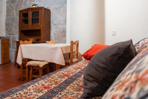 a living room with a table and a couch with a pillow at Cosy apartment in Seia, 25 sqm, welcoming fireplace in Seia